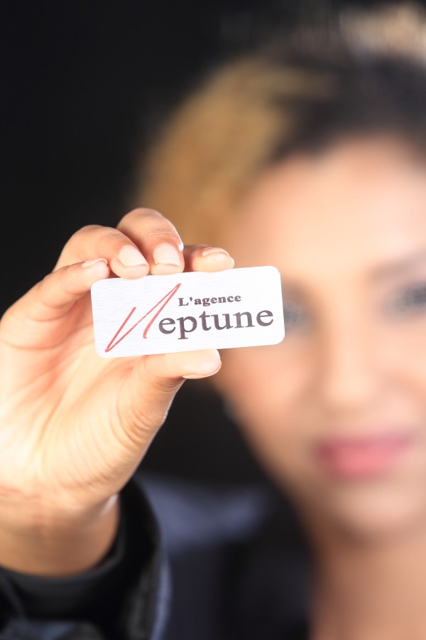 Badge de L'agence Neptune tenu par une hôtesse